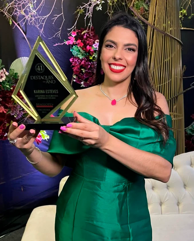 Karina Esteves segurando o prêmio Locutora Mais Ouvida, do Destaques do Ano Braslopes.
